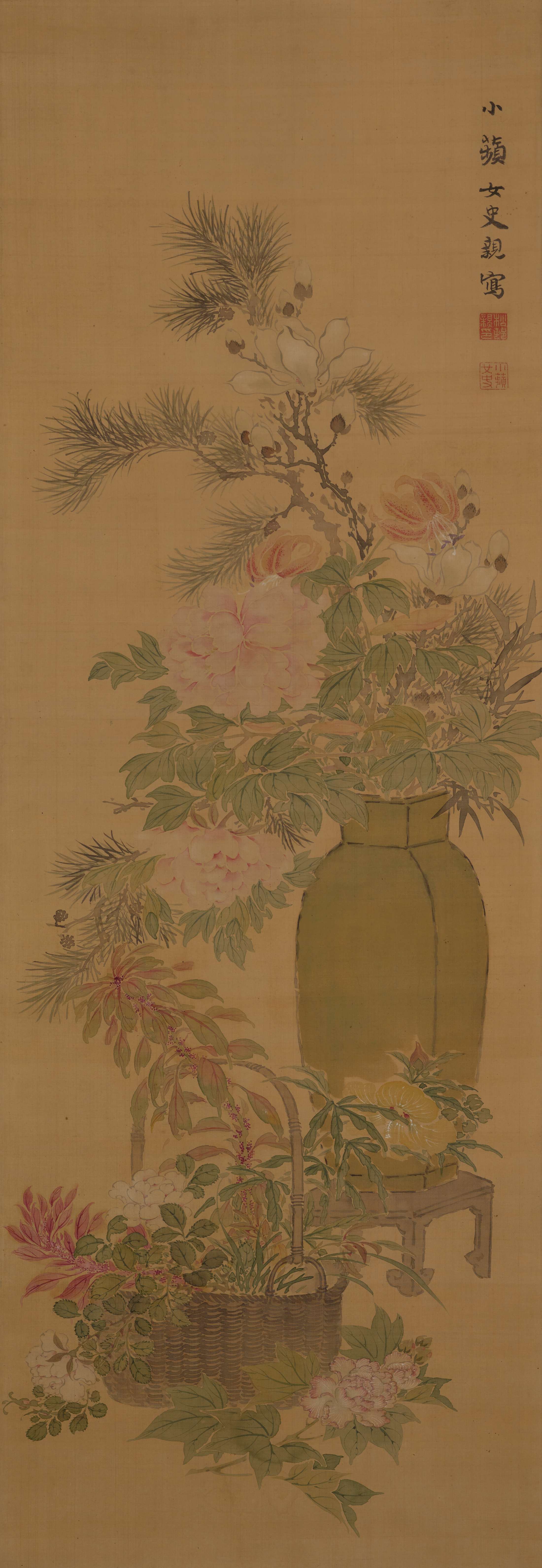 A wicker basket overflowing with flowers and foliage sits in the bottom foreground of a vertical composition. Behind it, a tall narrow vase on a short plant stand also overspills with blooming flowers, verdant foliage, and a pine bough.
