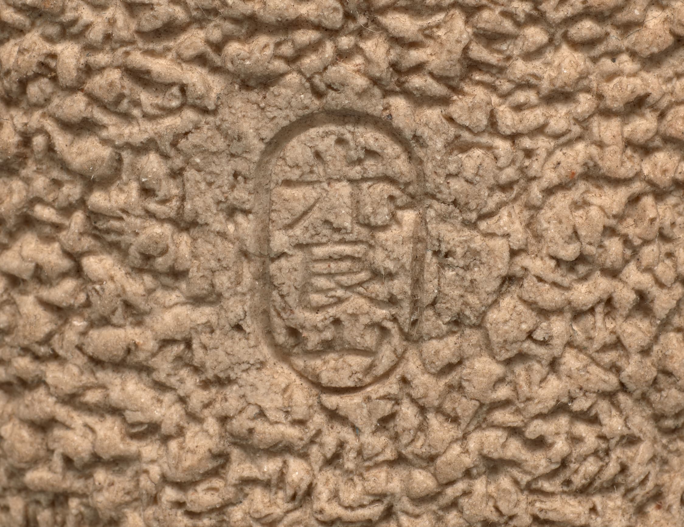 Close-up photo of the small stamp with Japanese characters on the rough outside of the teabowl.