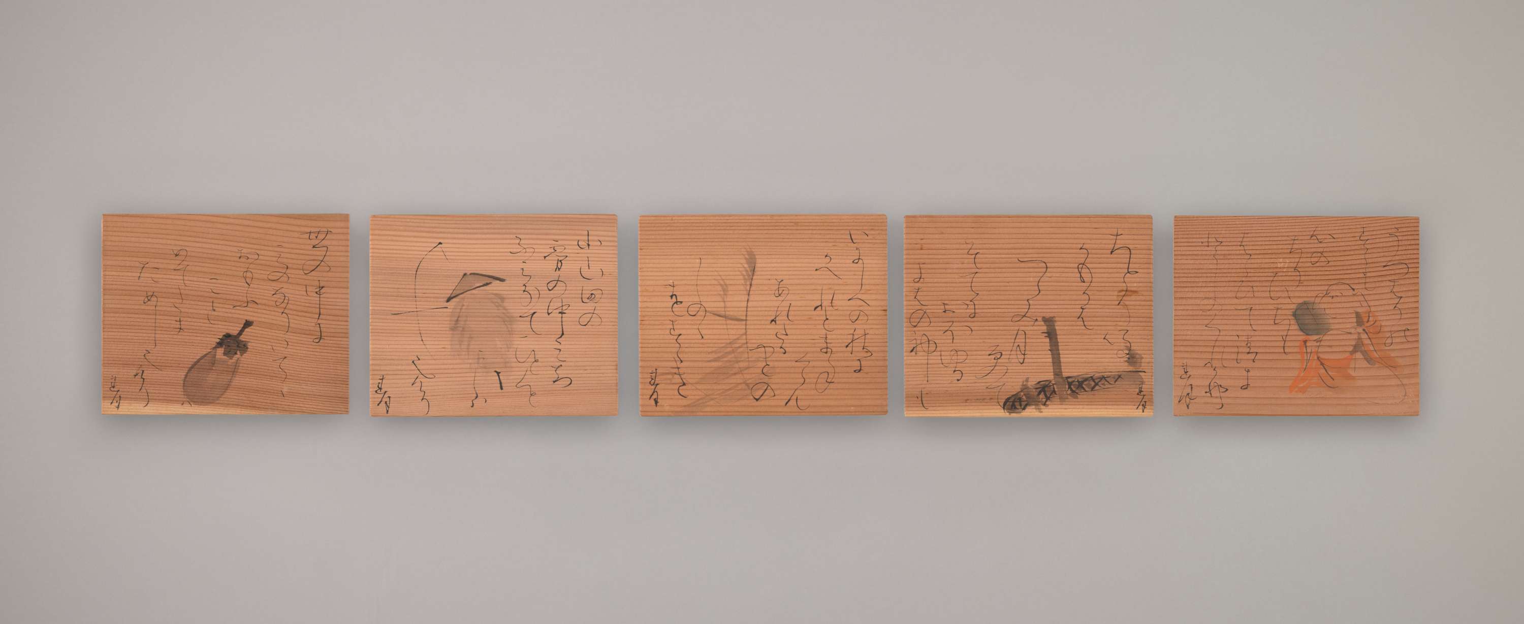 Small and flat rectangular wooden plates with painting and cursive calligraphy.